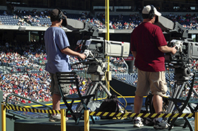 2 Camera Man Standing in a Green Metal Stage during Daytime