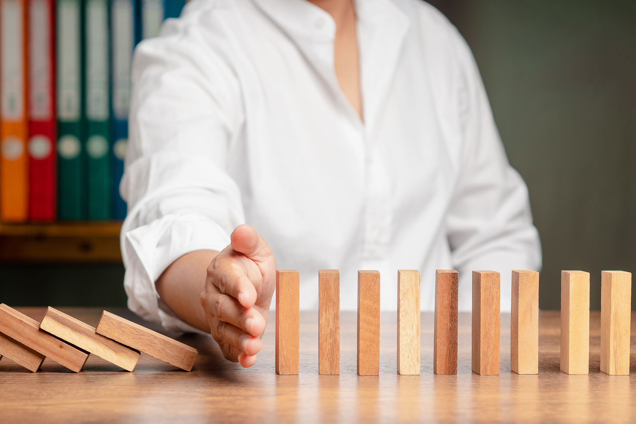 Mano de empresario deteniendo el efecto dominó de la crisis empresarial ante el colapso empresarial - Foto de stock de Adulto libre de derechos