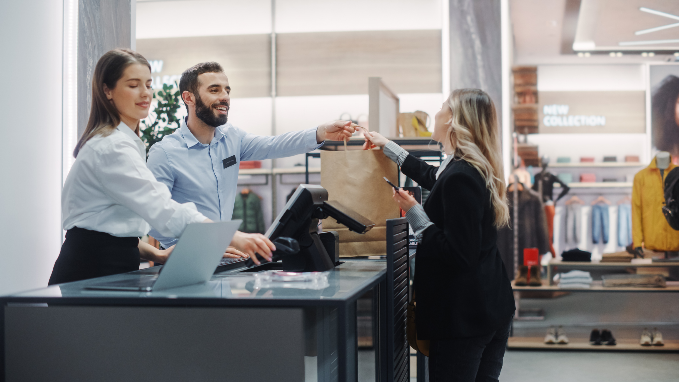 Dos empleados de ventas multirraciales en la tienda al momento de pagar - Foto de stock de Venta al por menor libre de derechos