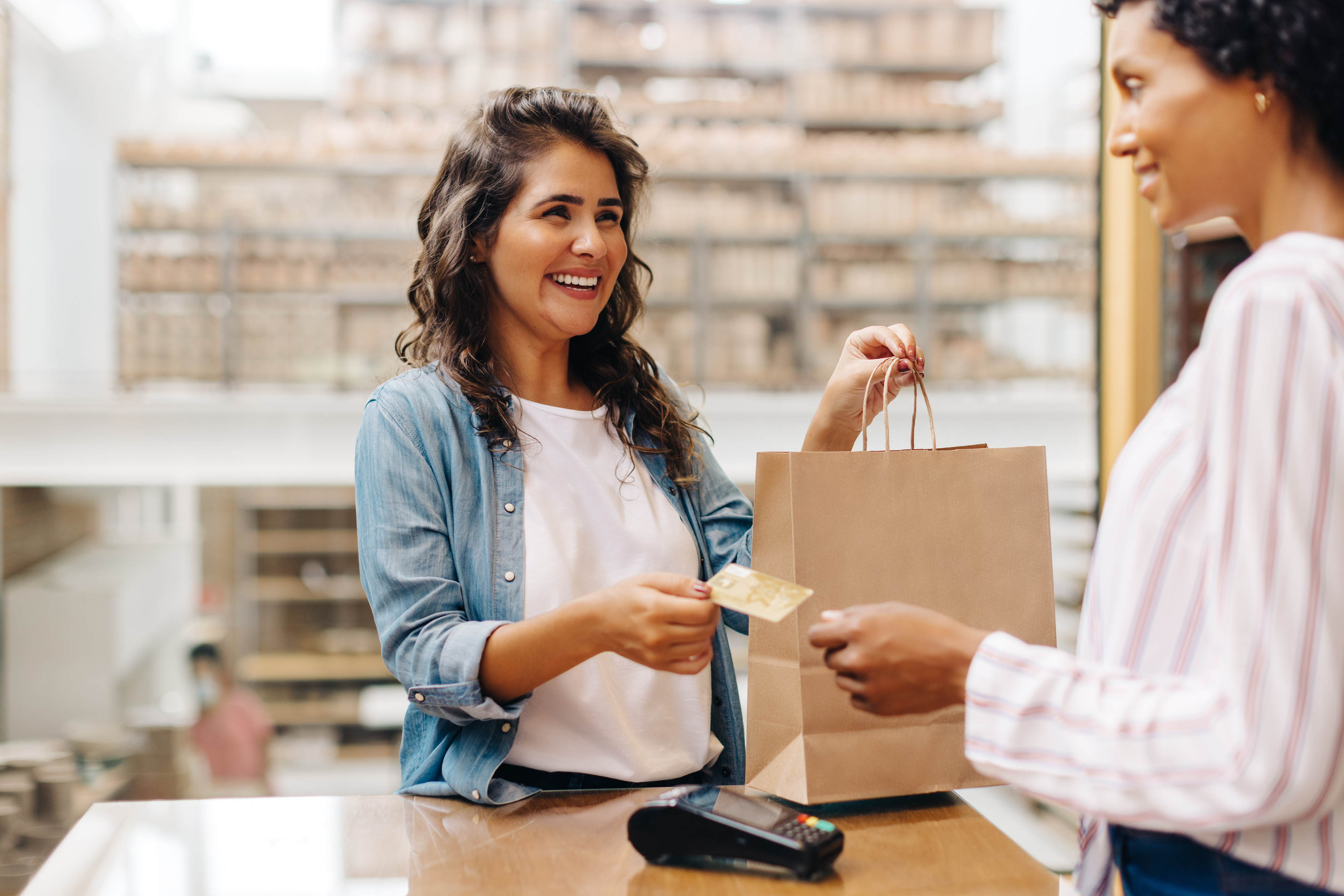 Cliente feliz pagando con tarjeta de crédito en una tienda de cerámica - Foto de stock de Venta al por menor libre de derechos